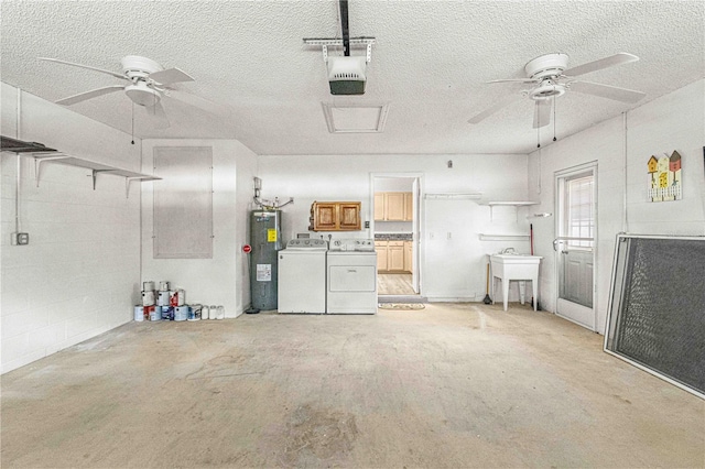 garage featuring separate washer and dryer, water heater, sink, and a garage door opener