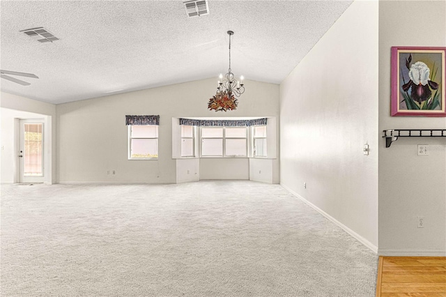 unfurnished room with carpet, ceiling fan with notable chandelier, a textured ceiling, and vaulted ceiling