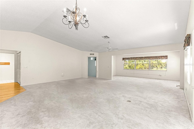 unfurnished living room with a textured ceiling, ceiling fan with notable chandelier, light carpet, and vaulted ceiling