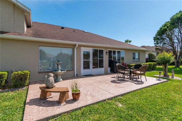 back of property with a lawn and a patio area