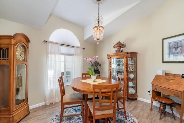 dining area with vaulted ceiling, light hardwood / wood-style floors, and a notable chandelier