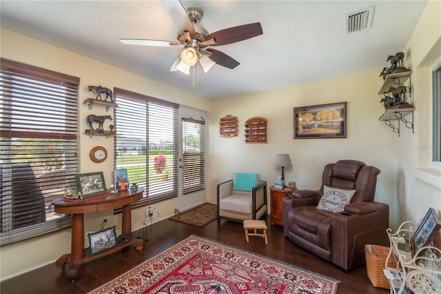 sitting room with dark wood-type flooring and ceiling fan