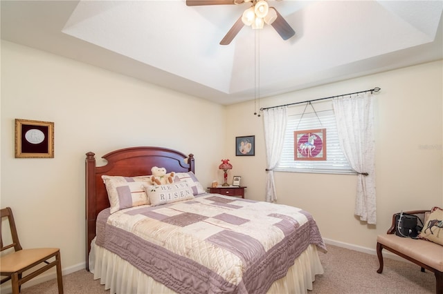 bedroom with light carpet, ceiling fan, and a tray ceiling