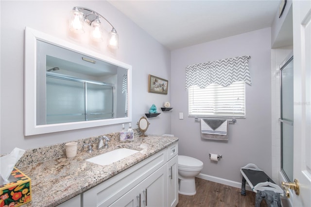 bathroom featuring vanity, hardwood / wood-style flooring, and toilet