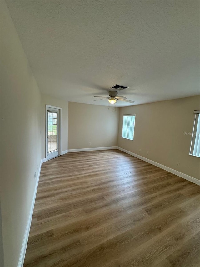 spare room with a textured ceiling, ceiling fan, and hardwood / wood-style floors