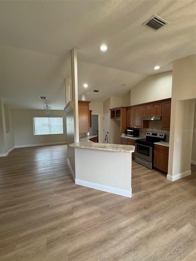 kitchen with stainless steel appliances, sink, light hardwood / wood-style flooring, a textured ceiling, and kitchen peninsula