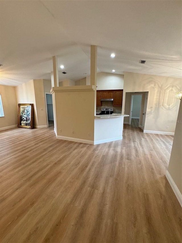 unfurnished living room featuring light wood-type flooring and vaulted ceiling