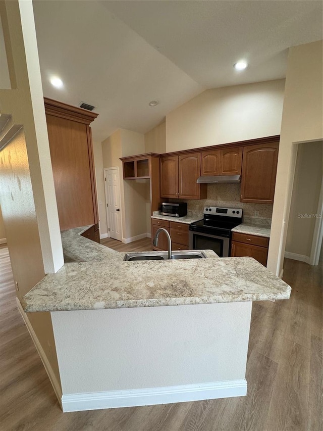 kitchen with stainless steel appliances, vaulted ceiling, sink, light hardwood / wood-style floors, and decorative backsplash