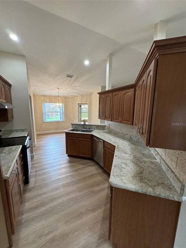 kitchen featuring range, kitchen peninsula, light hardwood / wood-style floors, hanging light fixtures, and sink