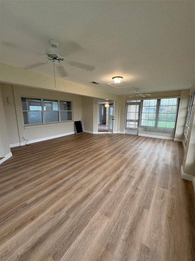 unfurnished living room with hardwood / wood-style flooring and ceiling fan