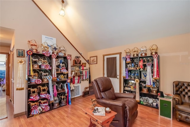 living area with vaulted ceiling and hardwood / wood-style flooring