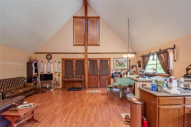 interior space with light hardwood / wood-style flooring, high vaulted ceiling, and a chandelier