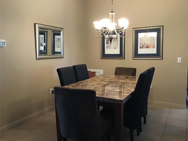 dining space with a chandelier and tile floors