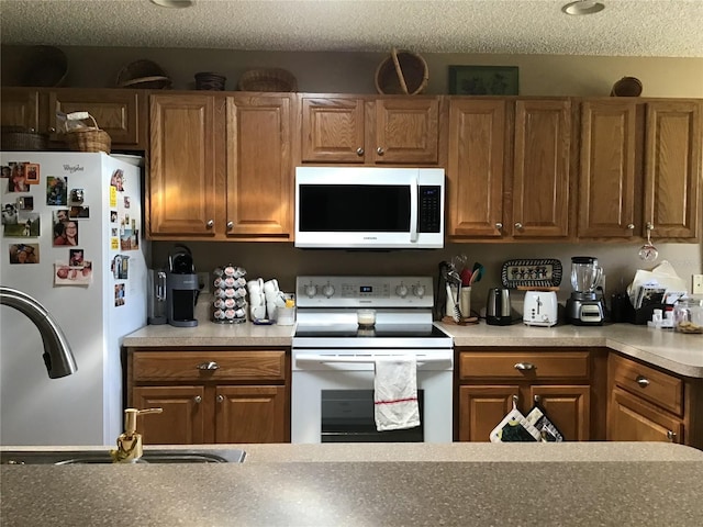 kitchen featuring white appliances and a textured ceiling