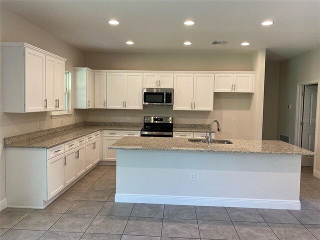 kitchen featuring sink, appliances with stainless steel finishes, a center island, and tile floors