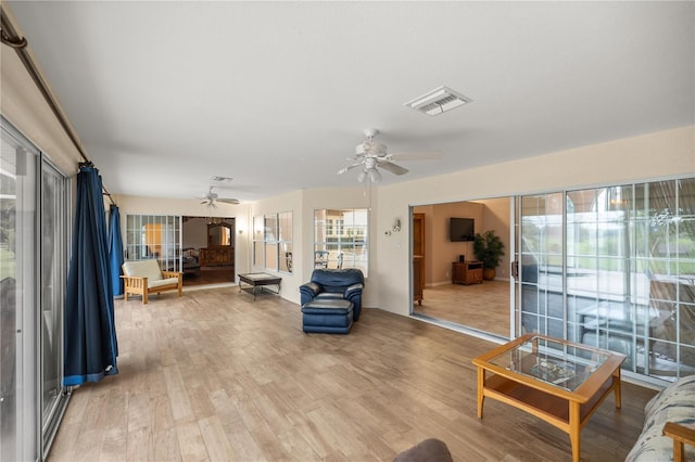 living room featuring ceiling fan and light hardwood / wood-style floors