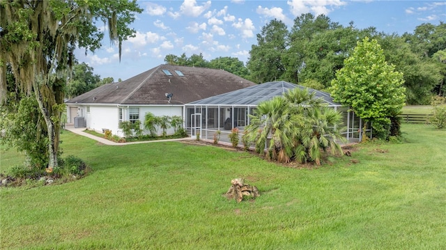 back of property featuring a yard and glass enclosure