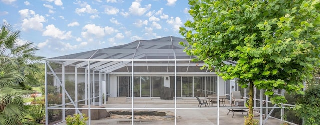 rear view of property with a patio and glass enclosure