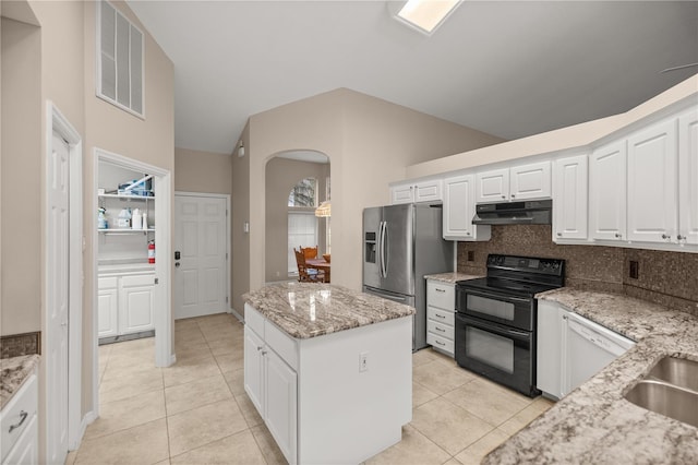 kitchen featuring light tile patterned floors, backsplash, a kitchen island, black electric range oven, and light stone countertops