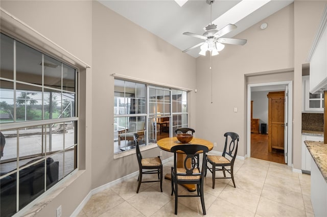 dining space with high vaulted ceiling, light tile patterned floors, and ceiling fan