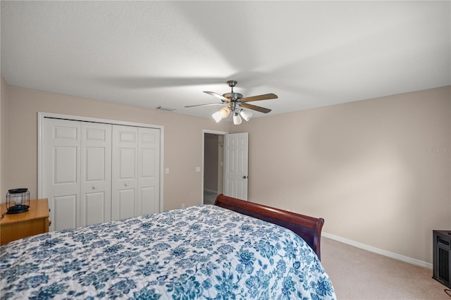 carpeted bedroom featuring a closet and ceiling fan