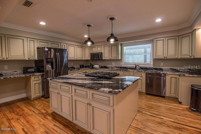 kitchen with dark stone counters, decorative light fixtures, light hardwood / wood-style floors, a kitchen island, and black appliances