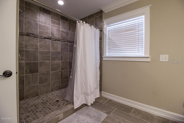 bathroom with tile patterned floors, ornamental molding, and walk in shower