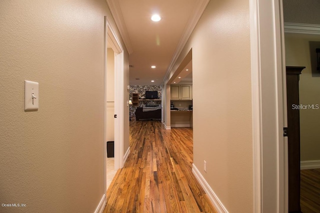 corridor featuring ornamental molding and light hardwood / wood-style flooring