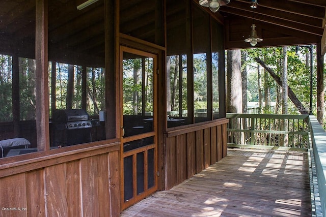 unfurnished sunroom featuring vaulted ceiling