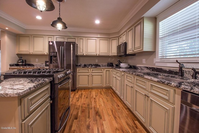 kitchen featuring sink, light hardwood / wood-style flooring, dark stone counters, decorative light fixtures, and appliances with stainless steel finishes