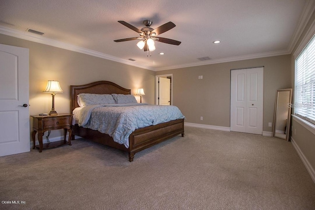 carpeted bedroom with ceiling fan, ornamental molding, and a closet