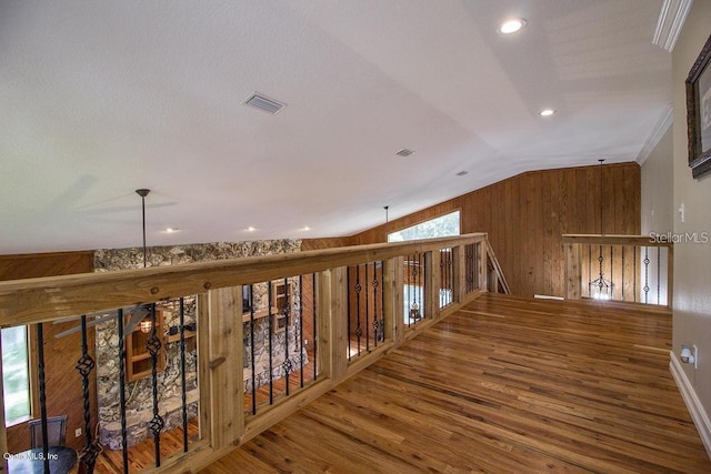 corridor featuring ornamental molding, hardwood / wood-style flooring, lofted ceiling, and a healthy amount of sunlight