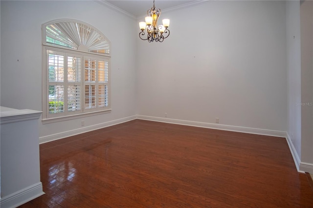 empty room featuring a chandelier, ornamental molding, and dark wood-type flooring