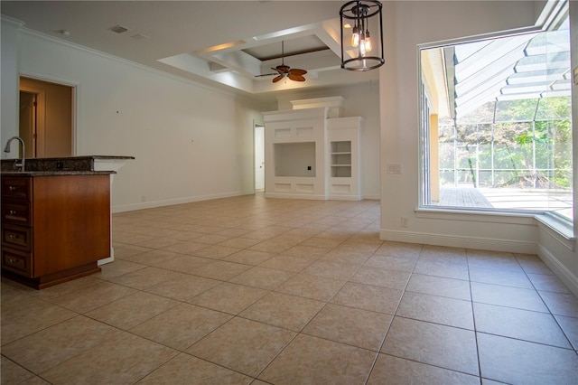 unfurnished living room with ceiling fan with notable chandelier, ornamental molding, a raised ceiling, and light tile floors