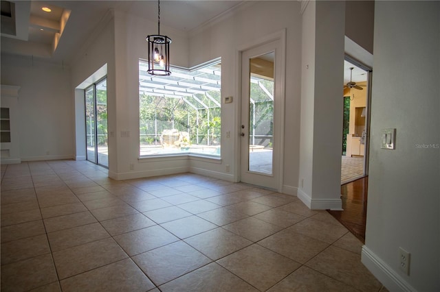 interior space featuring tile flooring, ceiling fan, ornamental molding, and a high ceiling