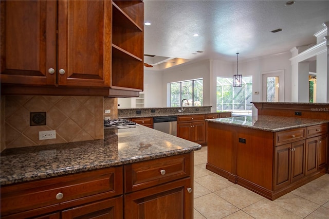 kitchen with backsplash, appliances with stainless steel finishes, a textured ceiling, dark stone counters, and sink