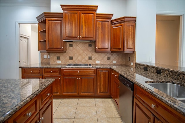 kitchen featuring appliances with stainless steel finishes, tasteful backsplash, dark stone countertops, light tile floors, and ornamental molding