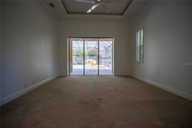 empty room featuring carpet, crown molding, a towering ceiling, a raised ceiling, and ceiling fan