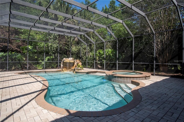 view of swimming pool featuring a patio area, an in ground hot tub, and a lanai