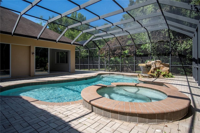 view of swimming pool featuring glass enclosure, an in ground hot tub, and a patio area