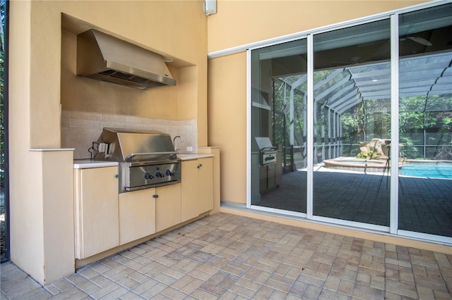 view of patio with exterior kitchen, a lanai, and grilling area