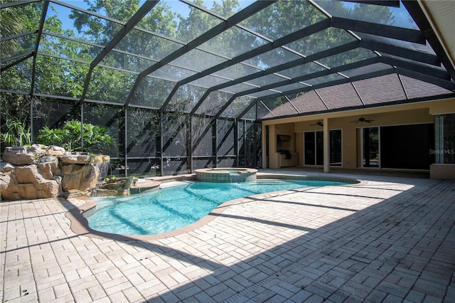 view of swimming pool featuring a patio area, ceiling fan, an in ground hot tub, and glass enclosure