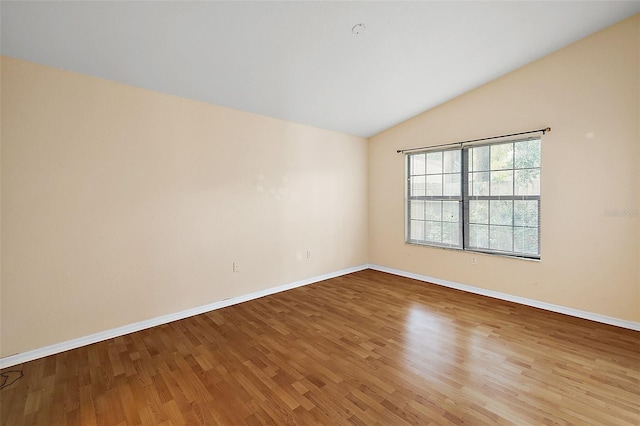 unfurnished room with wood-type flooring and vaulted ceiling