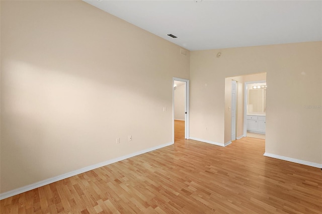 spare room featuring high vaulted ceiling and light wood-type flooring