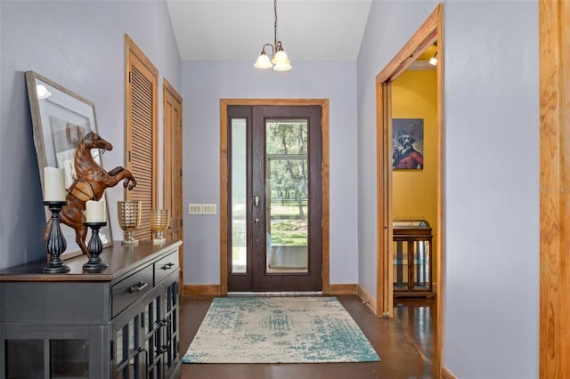 foyer featuring lofted ceiling, dark hardwood / wood-style flooring, and a notable chandelier