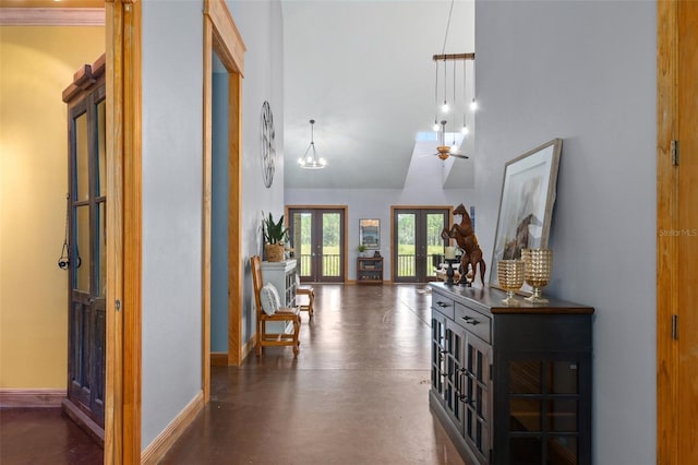 entryway with french doors, ceiling fan with notable chandelier, and a towering ceiling