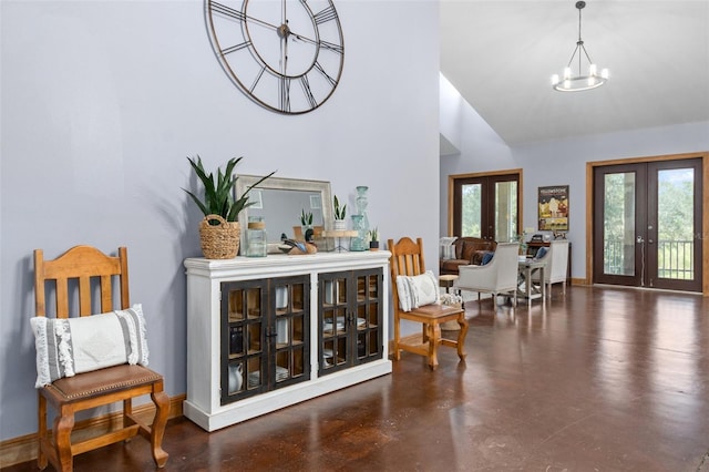 foyer featuring lofted ceiling, french doors, a healthy amount of sunlight, and a chandelier