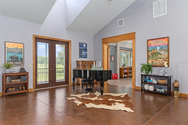 interior space with french doors, dark tile floors, a wealth of natural light, and high vaulted ceiling