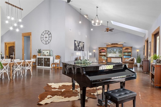 miscellaneous room with a skylight, high vaulted ceiling, and ceiling fan with notable chandelier