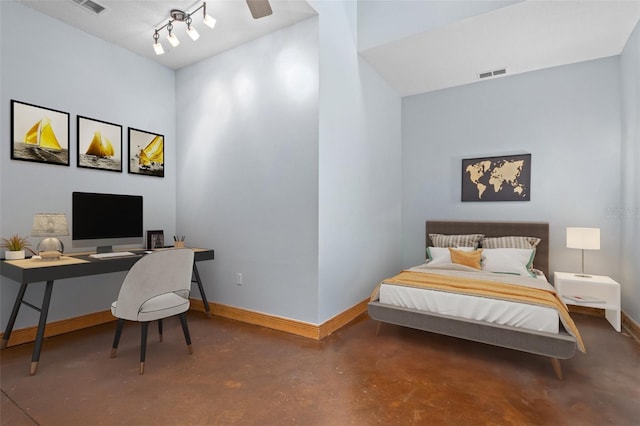 bedroom featuring concrete floors and track lighting